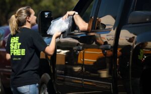 mohu employees handing out TV antennas to cars at a drive up event